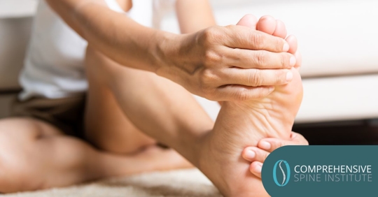 A woman holding her foot seemingly in pain