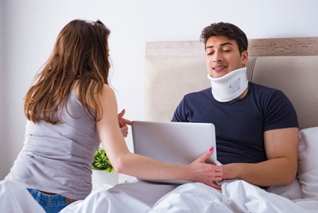 Woman assisting bedridden man with neck cast