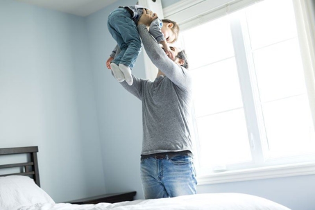 Man lifting his toddler son up in the air