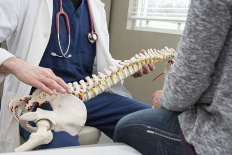 Doctor showing a patient a spine model