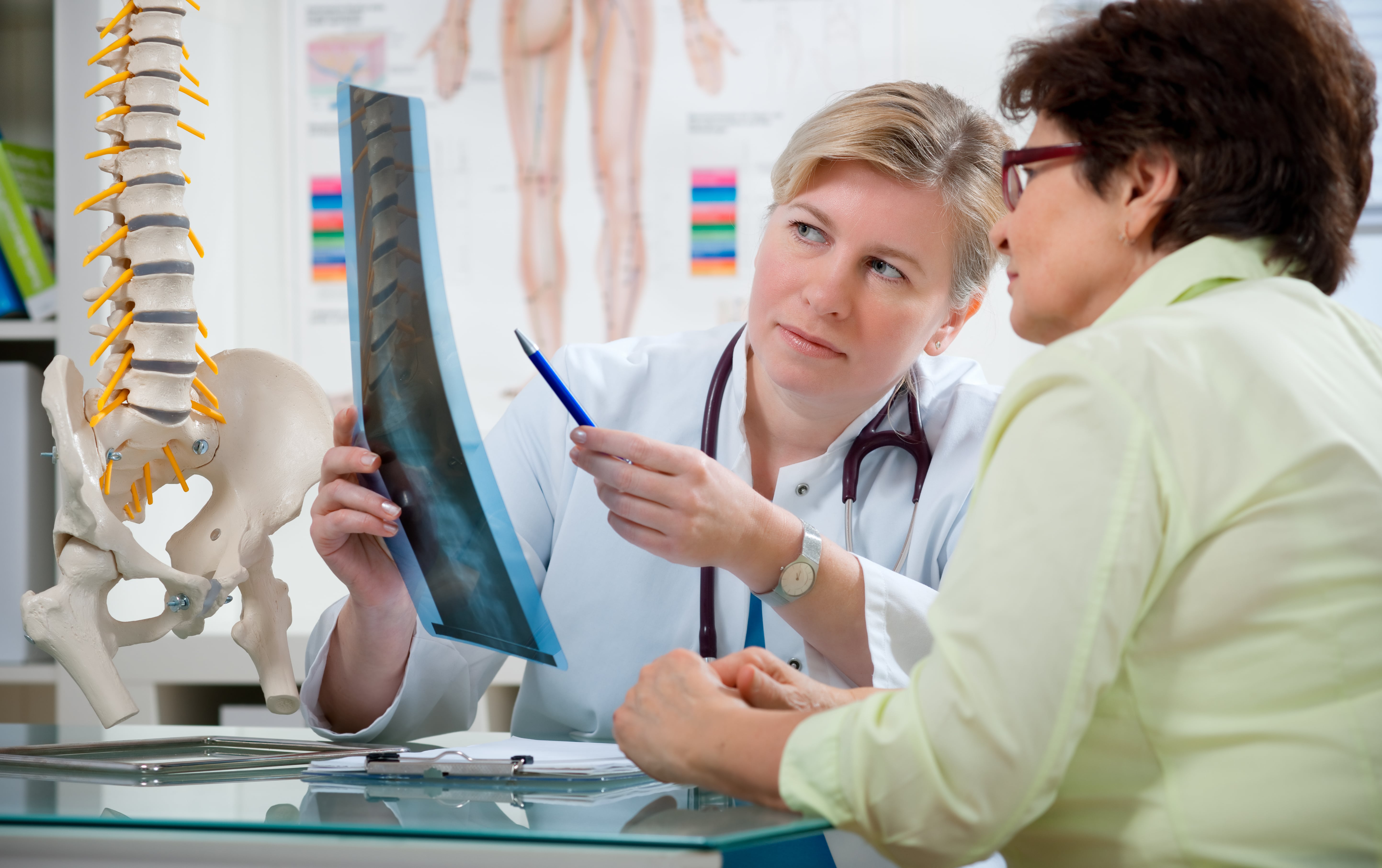 surgeon showing spine x-ray to patient